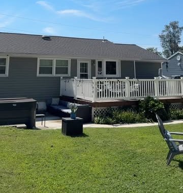 Aerial view of a ranch home with a deck and patio seating area