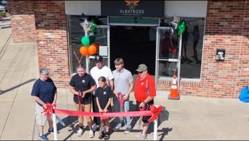 Aerial photo of a storefront grand opening ribbon-cutting ceremony