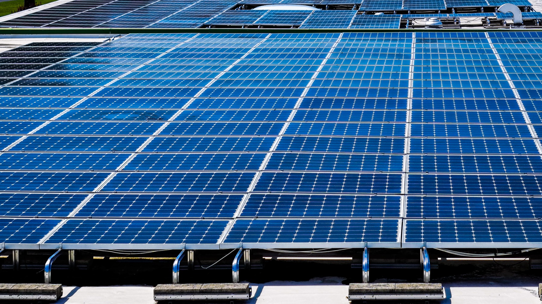 Close aerial view of a commercial rooftop solar panel array